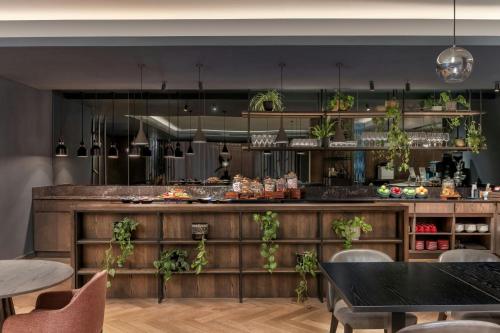 a restaurant with a counter with plants on it at Johannesburg Marriott Hotel Melrose Arch in Johannesburg
