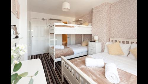 a bedroom with two beds and a desk at Entire Manor Grove Blackpool in Blackpool