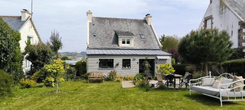 a house with a yard with a couch in front of it at Penn Ar Bed in Paimpol