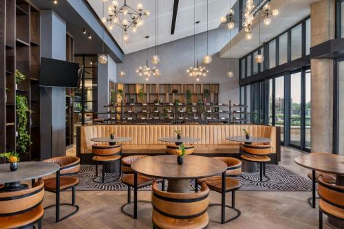 a restaurant with tables and chairs and a bar at Johannesburg Marriott Hotel Melrose Arch in Johannesburg