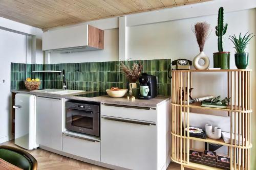 - une cuisine avec des appareils blancs et du carrelage vert dans l'établissement Le Nid Suspendu, à Lyon