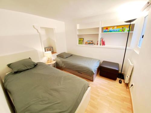 - une chambre avec 2 lits et une lampe dans l'établissement Appartement 4 à 6 personnes 20 mn de Paris, à La Celle-sous-Gouzon