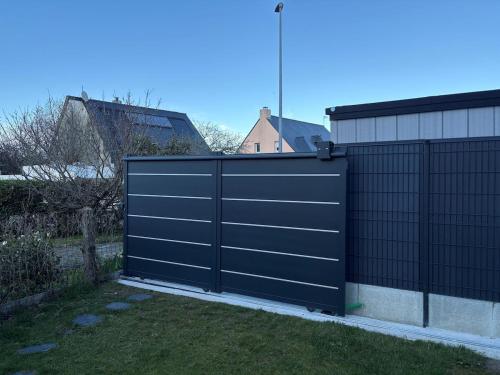 un portail noir sur le côté d'une maison dans l'établissement House with terrace and garden, à La Celle-sous-Gouzon