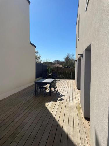 une terrasse en bois avec une table et des chaises dessus dans l'établissement House with terrace and garden, à La Celle-sous-Gouzon
