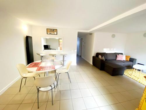 un salon avec une table, des chaises et un canapé dans l'établissement Appartement 4 à 6 personnes 20 mn de Paris, à La Celle-sous-Gouzon