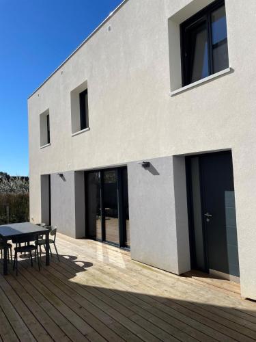 une maison avec une terrasse en bois et une table dans l'établissement House with terrace and garden, à La Celle-sous-Gouzon