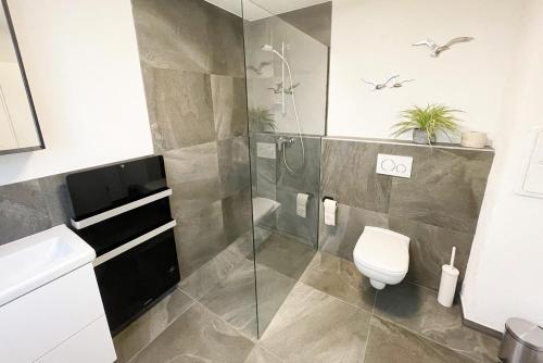 a bathroom with a shower and a toilet and a sink at 22A Große Wohnung mit Terrasse und Smart TV in Korb