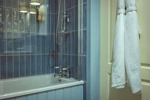 a bathroom with a shower and a tub and a sink at The Pierhouse Hotel in Port Appin