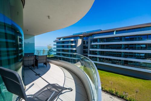 een balkon met een stoel en 2 gebouwen bij MyFlat Wave Premium40 Apartment in Siófok