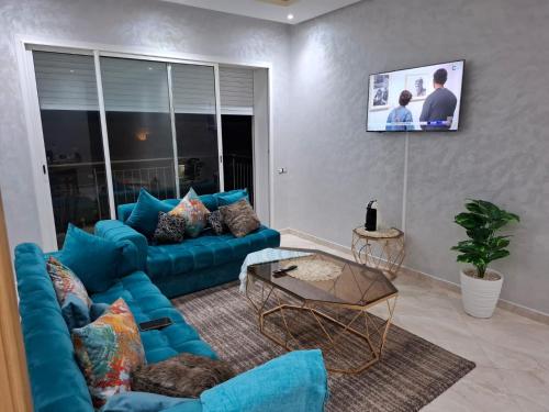 布兹尼盖Appartement vue panoramique的客厅里有一张蓝色沙发和一台电视