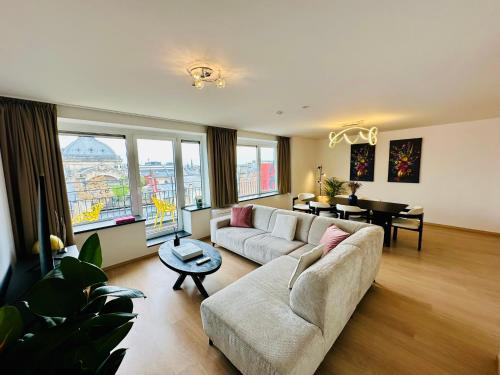a living room with a couch and a table at Grand Place View - 2bd - Exclusive Apartment in Brussels
