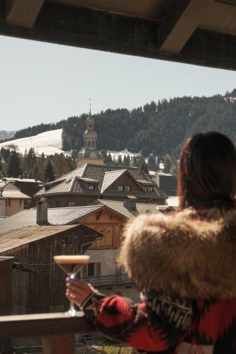 a woman looking out of a window at a city at Lodge Park in Megève