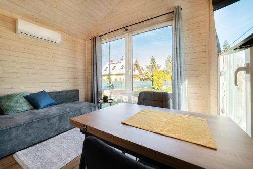 a room with a table and a couch and a large window at Domki Stolem in Jastarnia