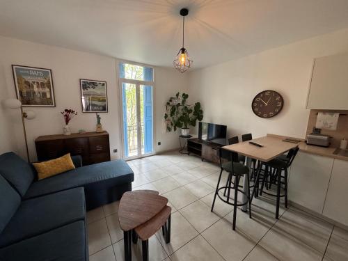 un salon avec un canapé bleu et une table dans l'établissement Emplacement idéal SECURISE T2 Cosy Perpignan, à Perpignan