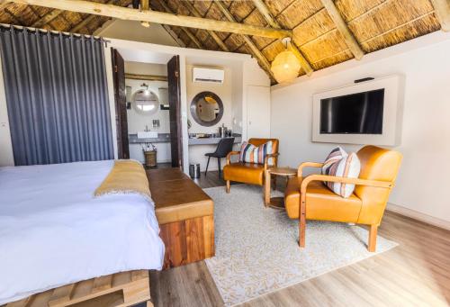 a bedroom with a bed and a table and chairs at Cradle Boutique Hotel in Lanseria