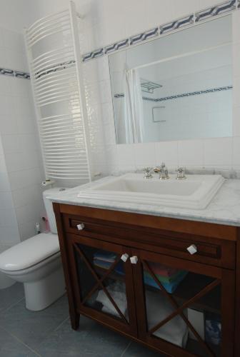 une salle de bain avec un lavabo, des toilettes et un miroir dans l'établissement Forville F4, à Cannes