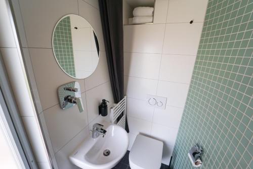 a bathroom with a sink and a toilet and a mirror at slube an der Marina Zehdenick in Zehdenick
