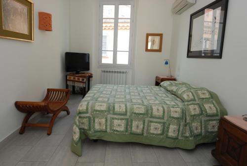 une chambre avec un lit, une chaise et une télévision dans l'établissement Forville F4, à Cannes