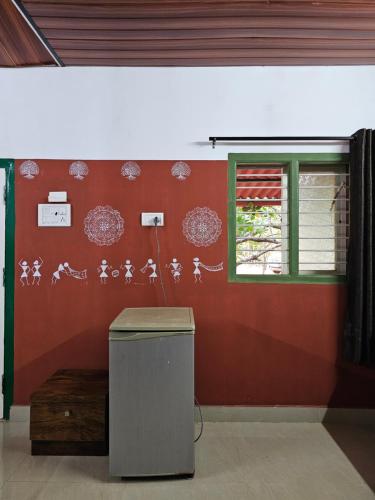 a room with a red wall with chinese writing on it at Farmhouse with Pool - Kalavady Farmstay in Baindūru