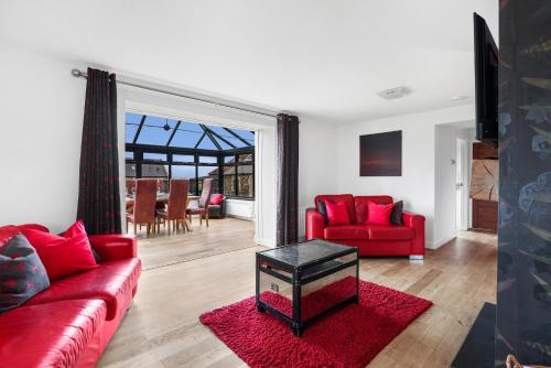 a living room with red furniture and a red couch at St Aidans Cottage - North East Escapes in Bamburgh