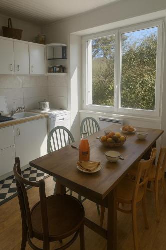 - une cuisine avec une table en bois et des fruits dans l'établissement Maison à 2 kms de la Plage, à Plomeur