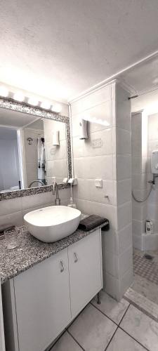 a white bathroom with a sink and a mirror at Driopon Apartment - Penthouse in Athens