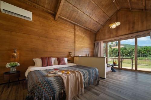 a bedroom with a bed and a large window at penida in Tianxin