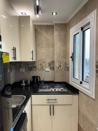 a kitchen with a stove and a sink and a window at Temple & Nile view in Luxor