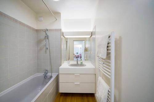 a bathroom with a tub and a sink and a bath tub at 100m Plage Antibes - Juan Appartement Stella Cœur in Antibes