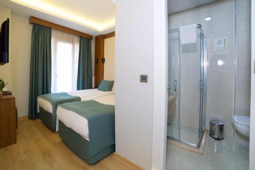 a hotel room with two beds and a shower at Hotel Black Tulip in Istanbul