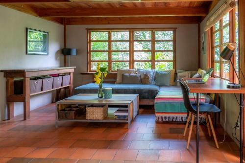 a living room with a couch and a table at Charming Cosy Chirripó Mountain Riverfront Cottage in Canaán