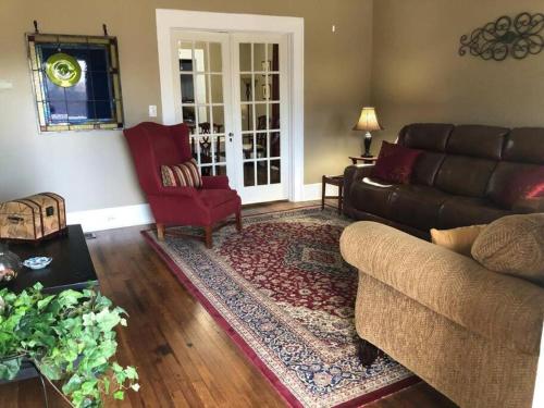 a living room with a couch and a red chair at The Farmhouse at Wolfehaven in Asheville
