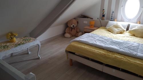 - une chambre avec un lit et un ours en peluche dans l'établissement Esprit Mer, à Gouville-sur-Mer