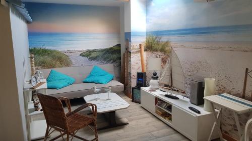 Cette chambre dispose d'un canapé, d'une télévision et d'un bureau. dans l'établissement Esprit Mer, à Gouville-sur-Mer