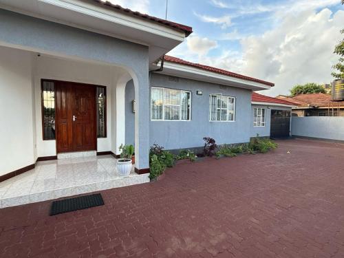 a house with a brick driveway in front of it at Elly's Three bedroom Home in Arusha