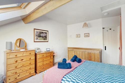 a bedroom with a blue bed and a wooden dresser at Heron View Cottage in Grasmere