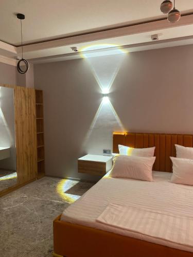 a bedroom with two beds and a light on the wall at Hectors Hotel in Kokand