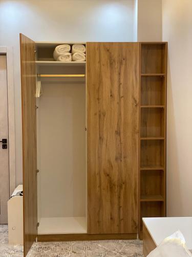 a closet with a wooden door and shelves at Hectors Hotel in Kokand