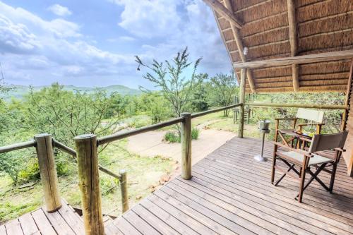 a wooden deck with a chair and a table on it at Cradle Boutique Hotel in Lanseria