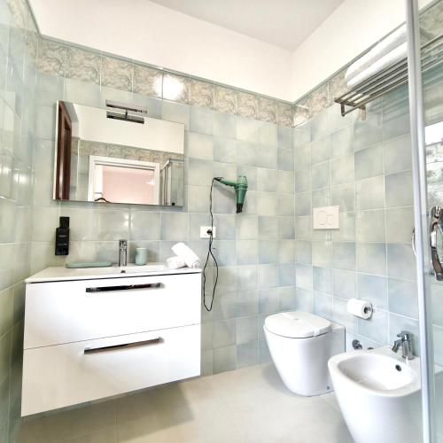a bathroom with a sink and a toilet and a mirror at Villamena in Spello
