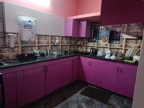 a kitchen with pink cabinets and purple counters at Ilford Castle Home Stay Pondicherry in Puducherry