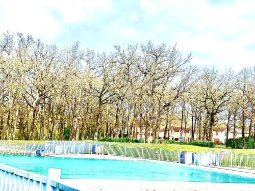 une piscine avec une clôture et quelques arbres dans l'établissement Studio cabine 5 personnes, à Monflanquin