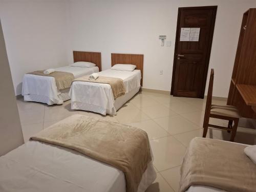 a hospital room with three beds and a door at Brisas do Mar HOTEL & APART in Valença