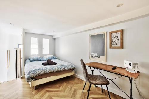une chambre avec un lit et un bureau avec une chaise dans l'établissement Le Nid Suspendu, à Lyon
