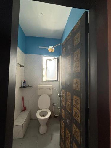 a bathroom with a toilet and a window at Ganges staycation in Nangi