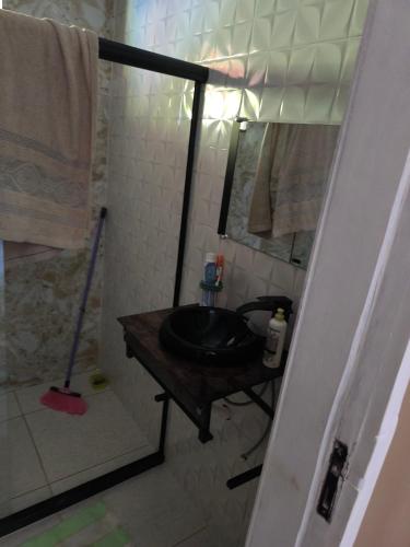 un bagno con un lavandino nero e una doccia di Casa de praia a Ilhéus