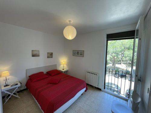 - une chambre avec un lit doté de draps rouges et une fenêtre dans l'établissement Appartement T3 spacieux, 6 couchages à Saint-Cyprien Plage, proche port et commerces, parking sécurisé - FR-1-106-38, à Saint-Cyprien