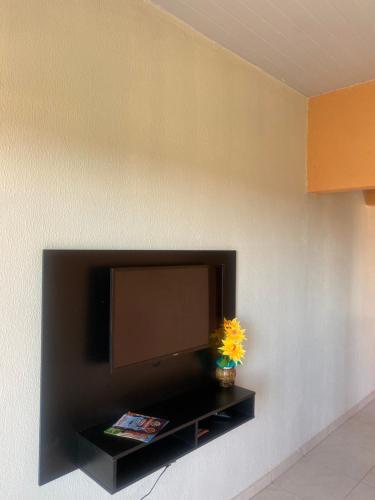 a flat screen tv on a wall with a flower at LM Flats - Beach Park Porto das Dunas in Aquiraz
