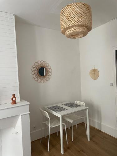 une salle à manger avec une table et des chaises blanches dans l'établissement Le Mi-Stud, à Castres