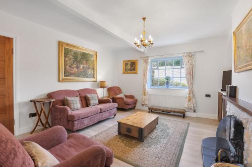 a living room with two couches and a fireplace at Spindlestone Cottage - North East Escapes in Bamburgh